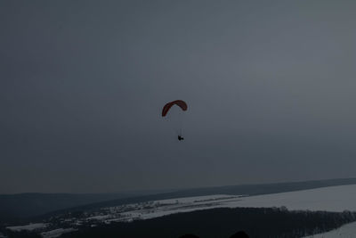 Person paragliding against sky