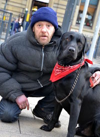 Portrait of man with dog sitting outdoors