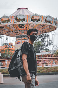 Young man wearing sunglasses standing against built structure