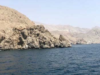 Scenic view of sea and mountains against clear sky