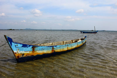 Boats moored on sea against sky