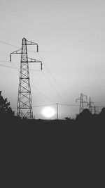 Silhouette electricity pylon against sky