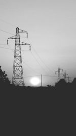 Silhouette electricity pylon against sky