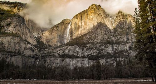 Scenic view of waterfall against mountains