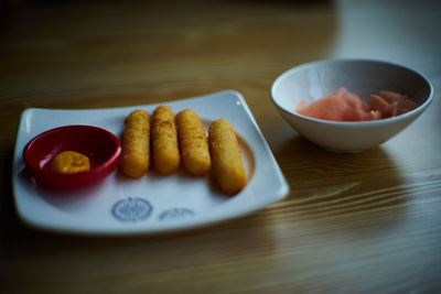 Cheese sticks in plate on table