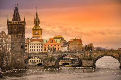 Arch bridge over river against buildings in city
