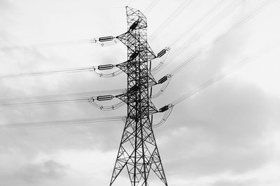 Low angle view of electricity pylon against sky