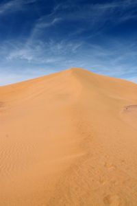 Low angle view of desert against blue sky