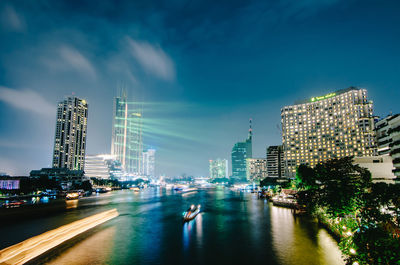 Illuminated modern buildings in city against sky