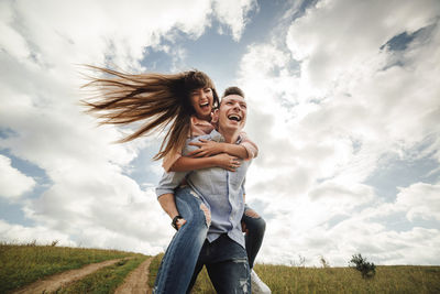 Full length of smiling girl on field against sky