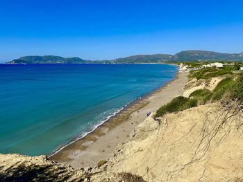 Scenic view of beach against clear blue sky