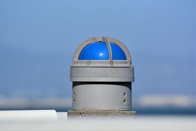 Close-up of metallic structure in sea against sky