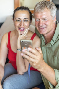 Smiling friends using phone