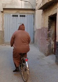 Rear view of man cycling on bicycle