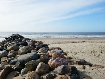 Pebbles on beach against sky