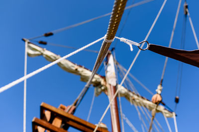 Low angle view of sailboat against blue sky