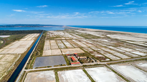 Aerial view of salt flat and sea against blue sky