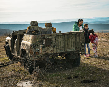 Rear view of woman standing by truck on field