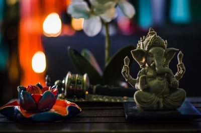 Close-up of ganesha statue with decoration on table at temple