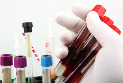 Close-up of hand holding objects over white background