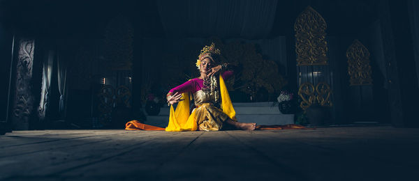 Woman sitting on sofa at home against building