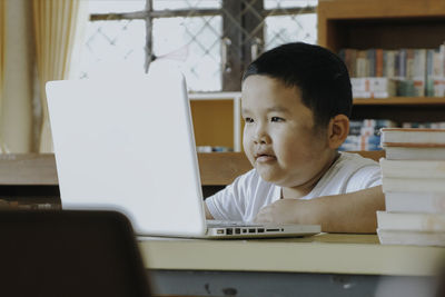Back to school, online learning, asian little child using laptop computer for online learning.
