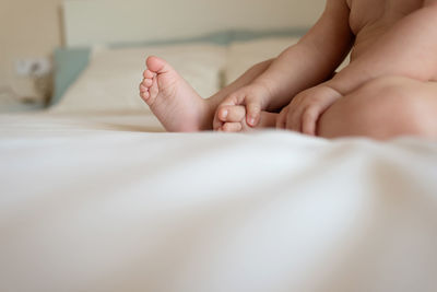 Unrecognizable baby boy lying on bed, close up