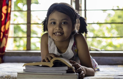 An indian cute girl child studying at home with smiling face