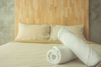 Towels rolled on bed in bedroom at home