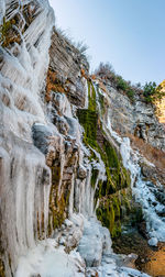 Scenic view of waterfall against sky during winter