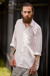 Portrait of young man standing against wall