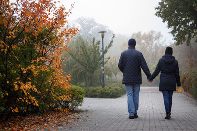 Rear view of woman walking on road
