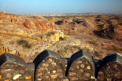 Fortified wall of mehrangarh fort on rocky mountains against clear sky