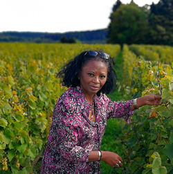 Portrait of young woman standing on field