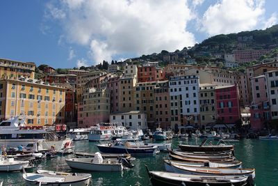 Panoramic view of boats moored at harbor against buildings in city