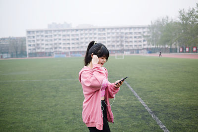Full length of woman standing on mobile phone
