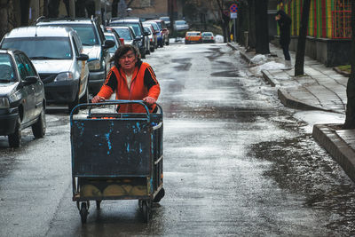 Woman with umbrella on street in city