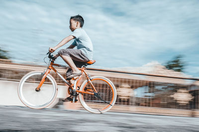 Man riding bicycle by lake