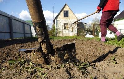 Gardener digging with garden spade in earth soil