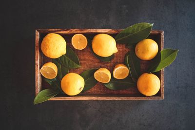 High angle view of fruits and leaves on cutting board