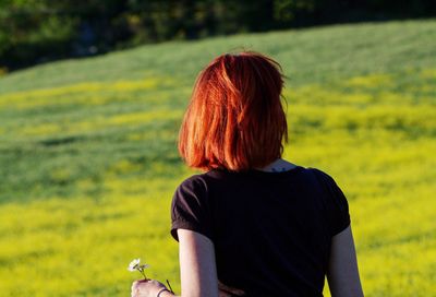 Rear view of woman standing on field