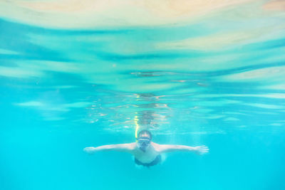 Shirtless man swimming in sea