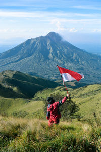 Red flag on mountain against sky