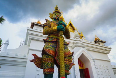 Low angle view of statues on building against sky