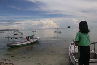 Rear view of man standing on sea against sky