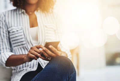 Midsection of woman using mobile phone