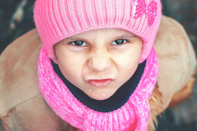 Close-up portrait of cute girl in pink knit hat