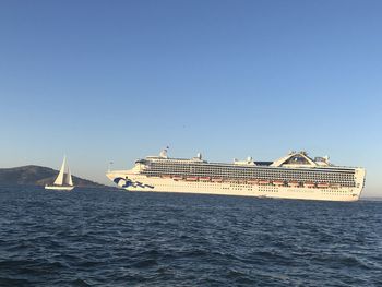 Ship sailing in sea against clear blue sky