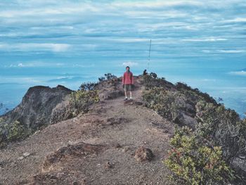 Full length of man standing on mountain against sky