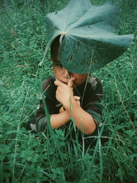 Girl holding plant on field